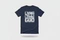 Person wearing a navy blue t-shirt with 'Living Proof of a Loving God' text and cross on the back, standing on a street.